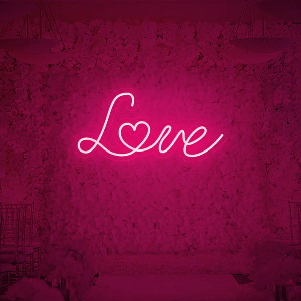 Love neon sign glowing in vibrant pink color