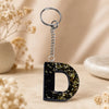 Personalised black resin alphabet D keychain with gold flakes