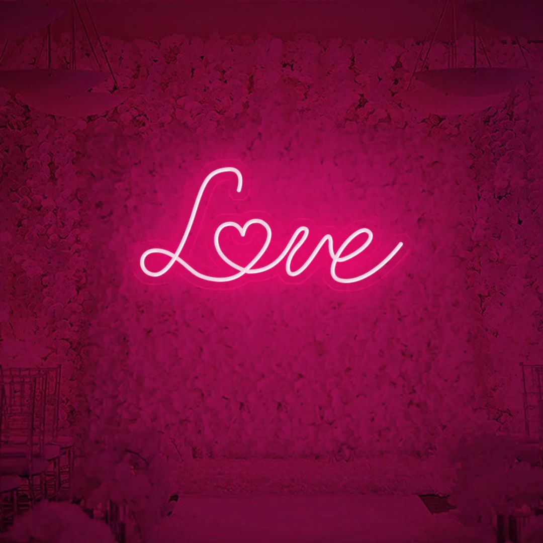 Love neon sign glowing in vibrant pink color