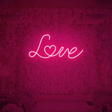 Love neon sign glowing in vibrant pink color