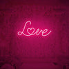 Love neon sign glowing in vibrant pink color