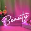 Neon sign with the word 'Beauty' on a soft pink background with flowers.