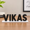 Office desk name plate with personalized black 3D letters on a white base