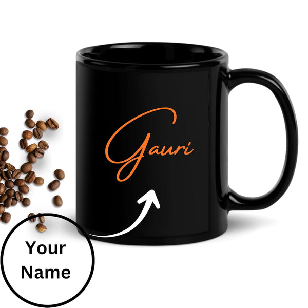 Black mug with 'Gauri' in orange text, surrounded by coffee beans on a white background.